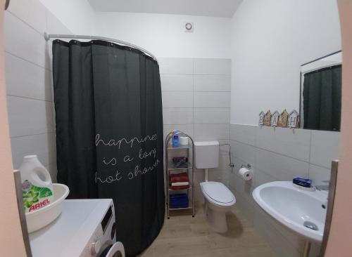 a bathroom with a black shower curtain and a toilet at ON BOARD in Piran