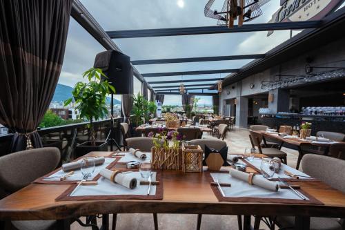 ein Restaurant mit Tischen und Stühlen auf einem Balkon in der Unterkunft Austrian Palace Hotel in Skopje