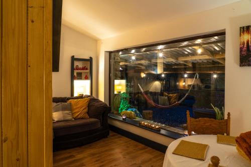 a living room with a large window with a couch and an aquarium at Retreat Lodge in Muff