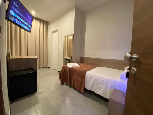 a hotel room with a bed and a flat screen tv at Hotel Vintage Milano Centrale in Milan
