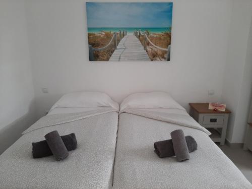 1 cama con 2 almohadas y una foto en la pared en Casa las Águilas, Lajares, en Lajares
