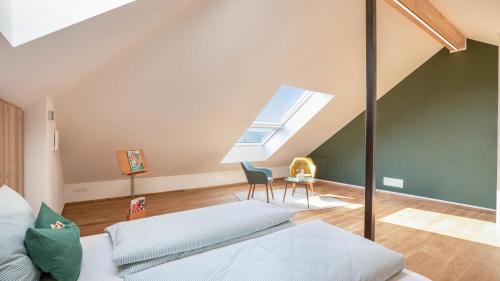 a attic room with a bed and a window at Meine Bleibe Apartment Olive in Appiano sulla Strada del Vino