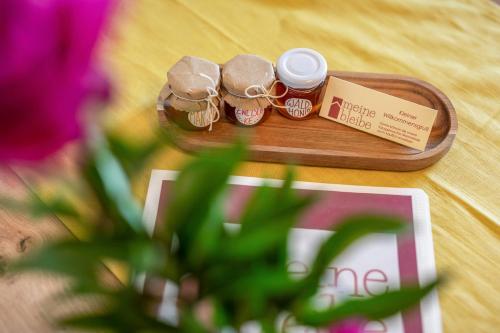 a wooden tray with three jars of honey and a plant at Meine Bleibe Apartment Olive in Appiano sulla Strada del Vino