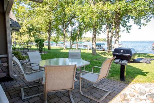 a patio with a table and chairs and a grill at Interlachen Unit 18 in Nisswa