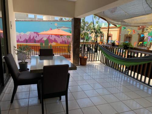 un patio con mesa, sillas y hamaca en Desert Heart Hostel en San José del Cabo