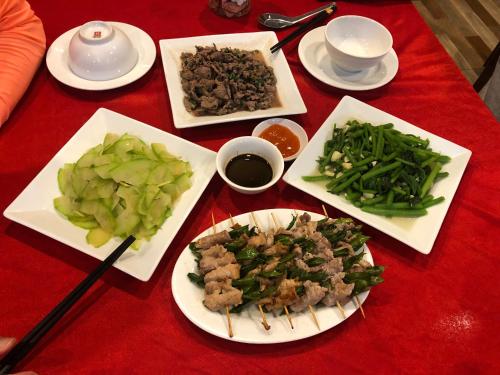 a table with plates of food on a red table at Ba Be Hostel in Bak Kan
