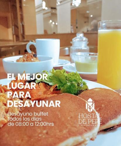 a plate with a sandwich and a glass of orange juice at May Palace Hotel  in Tuxpan de Rodríguez Cano
