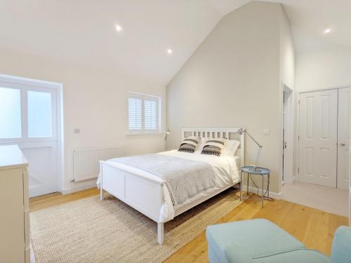 a white bedroom with a white bed and a window at Little Maplewood, Tangmere in Tangmere