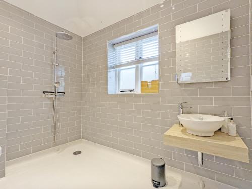 a bathroom with a sink and a shower at Little Maplewood, Tangmere in Tangmere