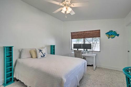 - une chambre avec un lit, un bureau et un ventilateur de plafond dans l'établissement Palm City Canalfront Home with Tiki Hut and Dock!, à Palm City