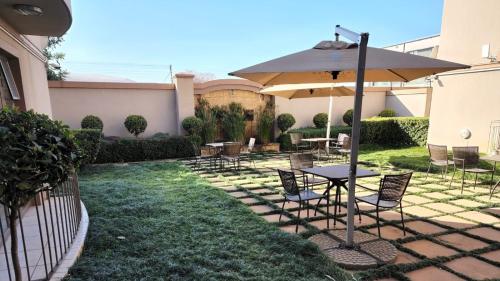 eine Terrasse mit einem Tisch, Stühlen und einem Sonnenschirm in der Unterkunft Homely Apartment, Hatfield, Unit-9 in Pretoria