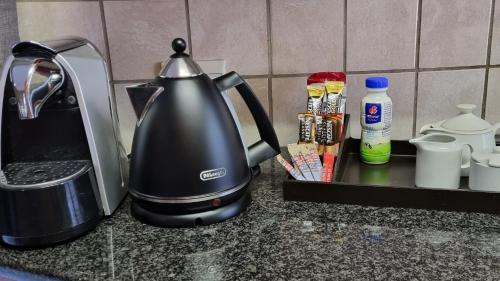 un bollitore per il tè seduto su un bancone della cucina con spezie di Homely Apartment, Hatfield, Unit-9 a Pretoria