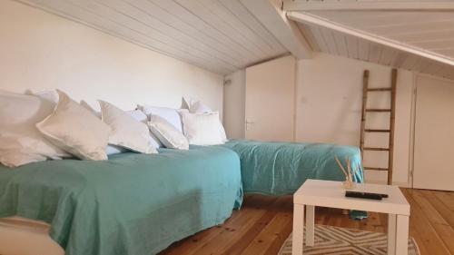 Cette chambre comprend 2 lits avec des oreillers et une échelle. dans l'établissement Joli duplex au centre du Canon à quelques pas du Bassin, à Cap-Ferret