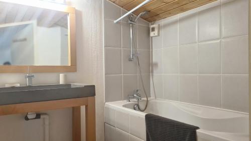une salle de bain avec un lavabo et une baignoire dans l'établissement Joli duplex au centre du Canon à quelques pas du Bassin, à Cap-Ferret