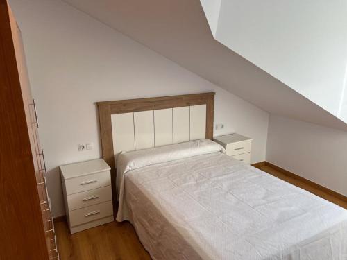 a bedroom with a bed and two night stands at Atico Plus A Valenzá in Ourense