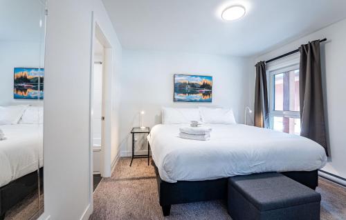 a bedroom with a large white bed and a window at RendezView by Revelstoke Vacations in Revelstoke