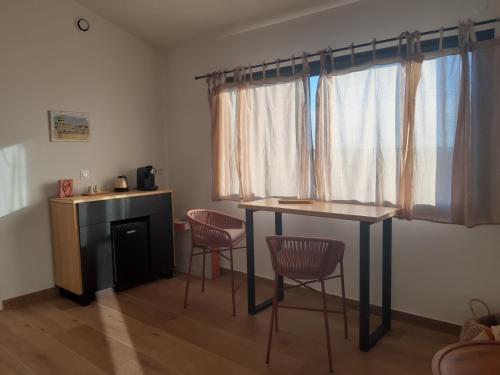 a room with a table and chairs and a window at La lagune aux oiseaux in Palavas-les-Flots