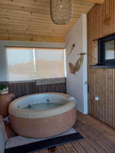 y baño con bañera grande y techo de madera. en La lagune aux oiseaux en Palavas-les-Flots