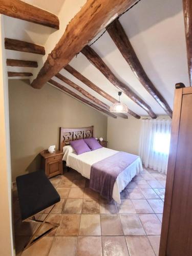 a bedroom with a large bed with purple sheets at CASA RURAL SANTA AGUEDA in Jaraba