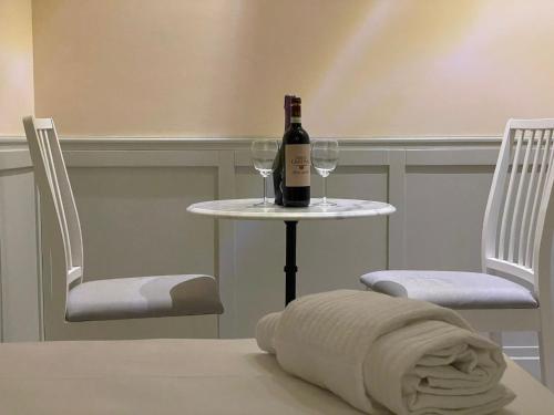 a bottle of wine sitting on a table with two glasses at Casa di Stefano in Rome