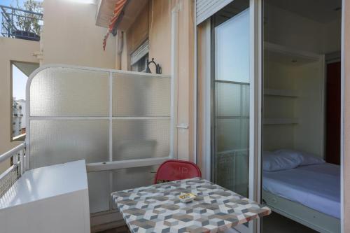 Cette petite chambre comprend une petite table et une fenêtre. dans l'établissement Studio des Orangers - Welkeys, à Nice