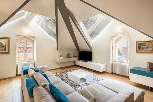 a living room with a couch and a tv at Il Golfo Attico Vista Lago in Toscolano Maderno