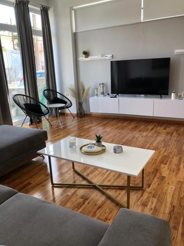 a living room with a couch and a table at New delux studio with wooden floor in Chania Town