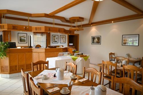 ein Restaurant mit Tischen und Stühlen und eine Küche in der Unterkunft Pension Christine in Großweikersdorf