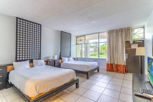 a hotel room with two beds and a desk at 502 Little Harbor Inn in Ruskin