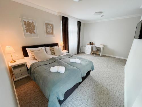 a bedroom with a large bed with two towels on it at Villa Adele in Polanica-Zdrój