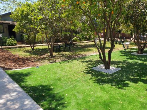 a park with trees and benches in the grass at אירוח פינת חן in Ramot Naftali