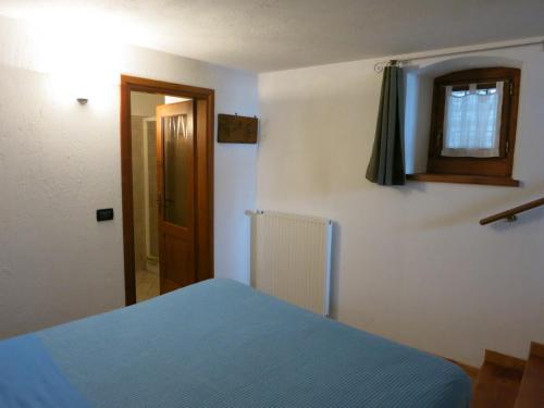 a bedroom with a blue bed and a window at Dialley prato Cir0014 in Aymavilles