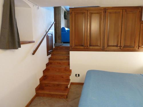 eine Treppe mit einem blauen Bett und Holzschränken in der Unterkunft Dialley prato Cir0014 in Aymavilles