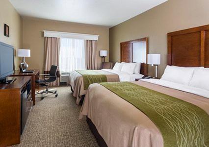 a hotel room with two beds and a desk at Comfort Inn Midland South I-20 in Midland