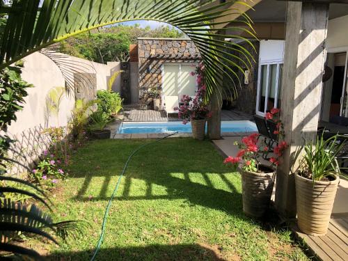 a backyard with a pool and a yard with plants at Elegant Villa in Grand Baie with Pool in Grand Baie