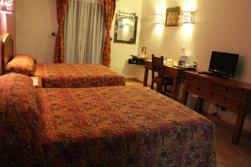 a hotel room with two beds and a desk at Hotel Casa Conzatti in Oaxaca City