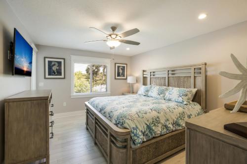 a bedroom with a bed and a ceiling fan at Royal Palm: Pool, 2 Blocks to Beach, Close to Dining & Shopping by Anna Maria Life Vacation Rentals in Holmes Beach