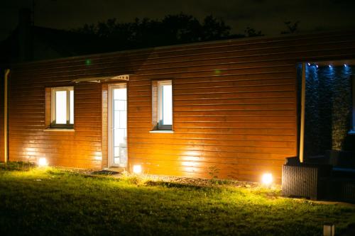 une maison avec des lumières sur son côté la nuit dans l'établissement Atelier chaleureux - CDG, à Tremblay-en-France