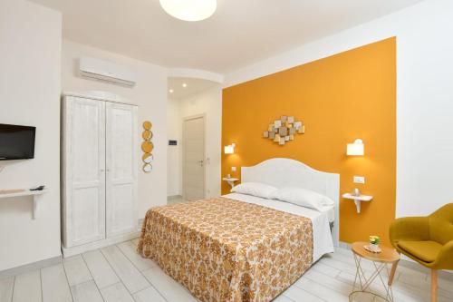 sypialnia z łóżkiem i żółtą ścianą w obiekcie B&B inCentro w mieście Santa Maria di Castellabate