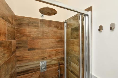 y baño con ducha con paneles de madera. en B&B inCentro en Santa Maria di Castellabate