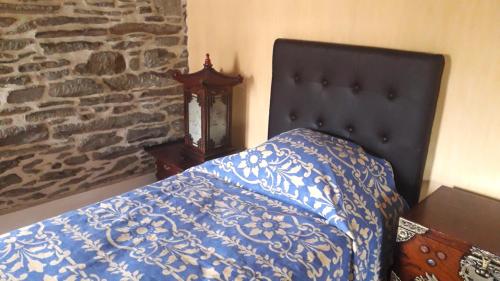 a bed with a blue and white comforter in a bedroom at Le cocon in Cherbourg en Cotentin