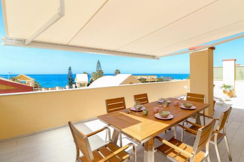 un comedor con mesa y sillas y el océano en Romana Playa beachfront, en Marbella