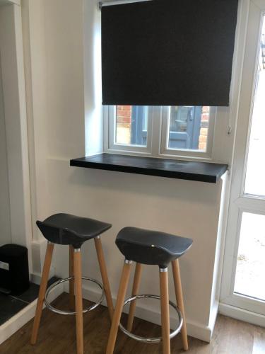 two black stools next to a counter with a window at Lovely Modern decorated 1 bed Studio in Newport