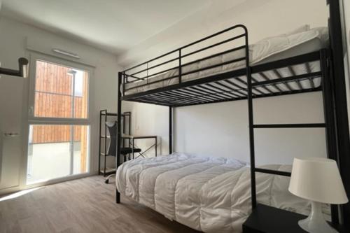 une chambre avec deux lits superposés et une lampe dans l'établissement Lumineux appt avec BALCON pour 4 pers à Vannes !, à Vannes