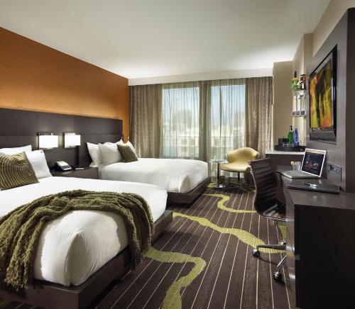 a hotel room with two beds and a desk at Hard Rock Hotel San Diego in San Diego