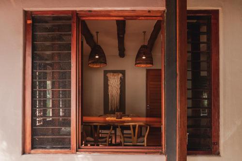 Casa Nalum في تولوم: نافذة غرفة طعام مع طاولة وأضواء