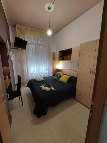a bedroom with a bed and a chair in it at Maison des Roses in Cesenatico