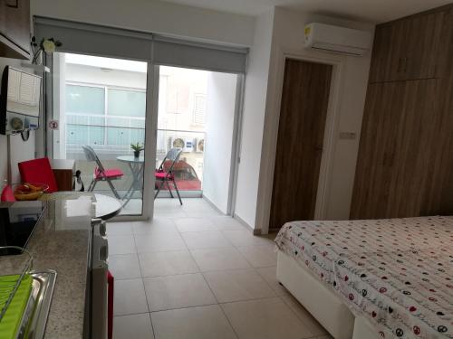 a bedroom with a bed and a kitchen with a table at Chicos Studios in Ayia Napa