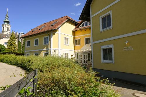 un groupe de bâtiments à côté d'une rue dans l'établissement Pension Christine, à Großweikersdorf