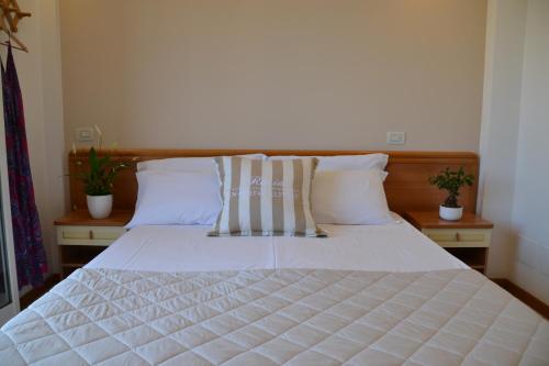 a bedroom with a bed with white sheets and pillows at Hotel Apogeo - Breakfast Experience in Rimini